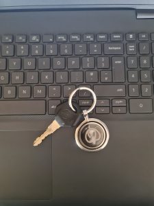 Bike's key with the keyring is on the laptop keyboard.