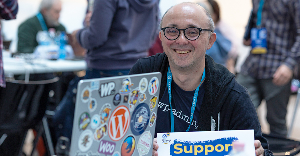 Stefano with a laptop covered in WordPress event stickers